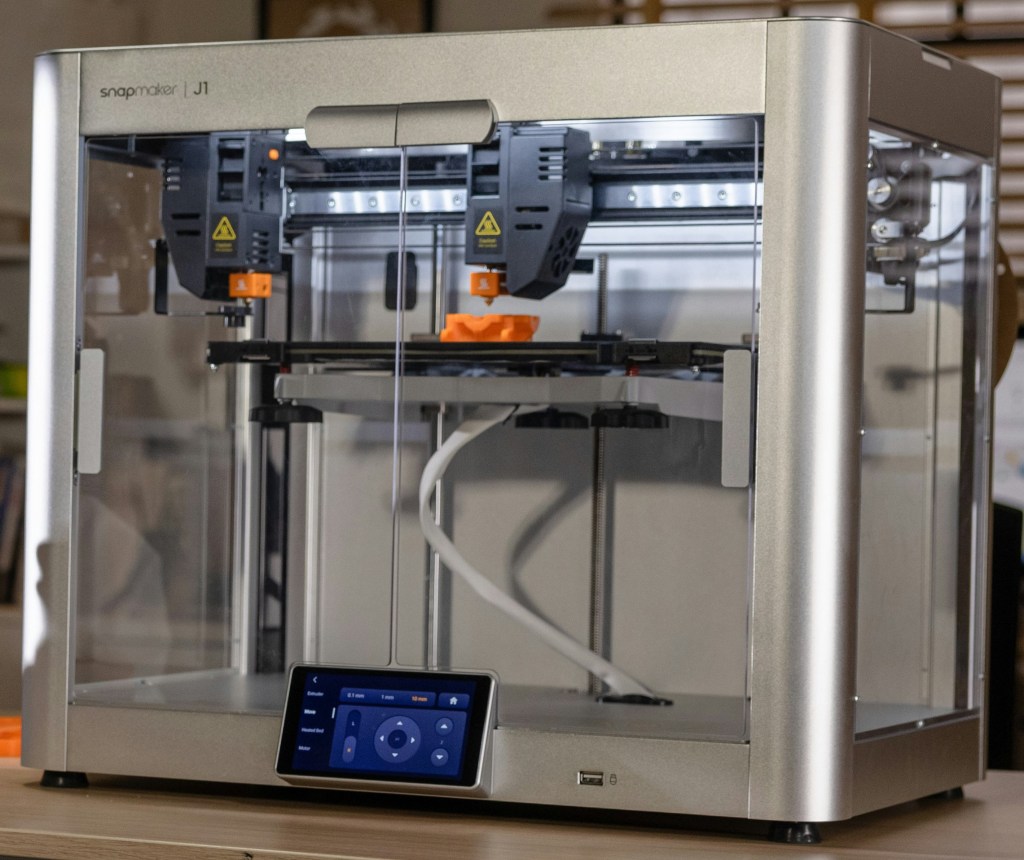 A 3D printer enclosed in a clear case.